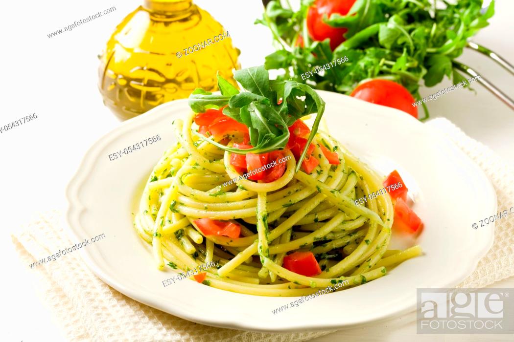 Stock Photo: photo of delicious pasta with arugula pesto and cherry tomatoes.