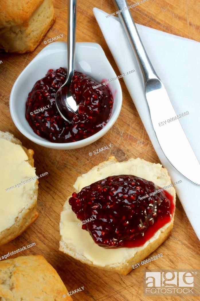 Stock Photo: scone with organic jam on a timber board.