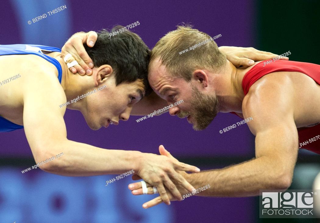 Stock Photo: Germany's Marcel Ewald (red) competes with Viktor Lebedev (blue) of Russia in the wrestling Men's 57kg Freestyle Final at the Baku 2015 European Games in the.