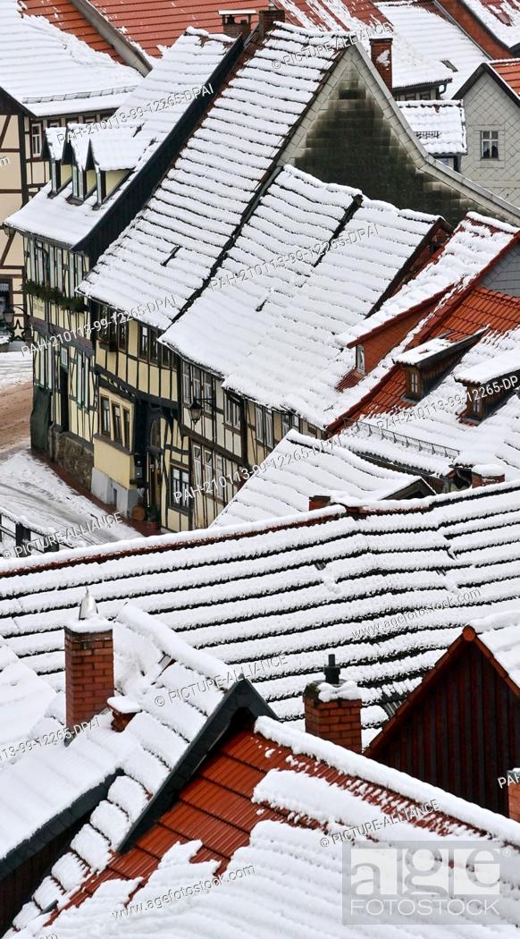 Stock Photo: 13 January 2021, Saxony-Anhalt, Stolberg: The roofs of the half-timbered town of Stolberg in the Harz Mountains are covered in snow.