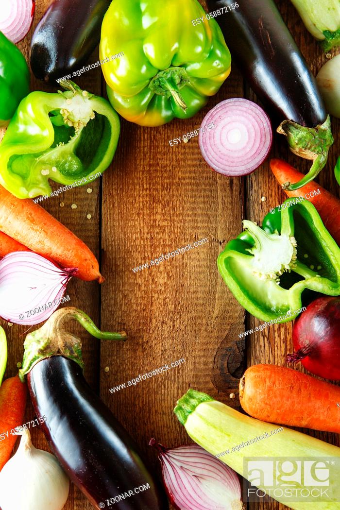 Stock Photo: Fresh vegetables and ingredients for cooking around vintage cutting board on rustic background, top view, place for text.