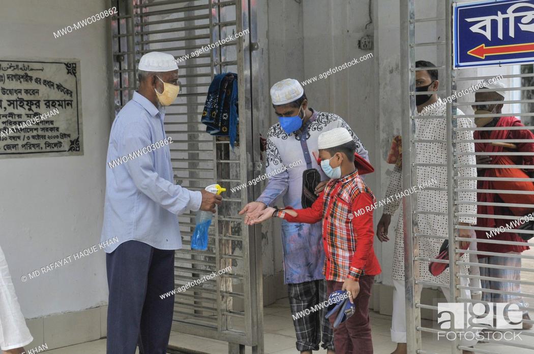 Stock Photo: in congregation at Hazrat Shahjalal (R)Sylhet, Bangladesh mosque staff providing sanitizer to the Muslims attend Friday prayers under the shadow of the Covid-19.