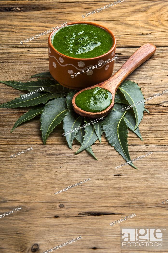 Stock Photo: Medicinal Neem leaves with paste on wooden background.