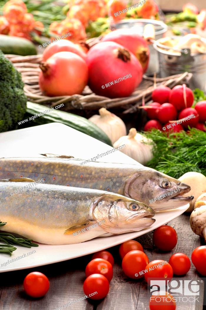 Stock Photo: Top view on huge wooden table: two raw, fresh rainbow trouts among vegetables. Idea of healthy living and valuable, natural food.