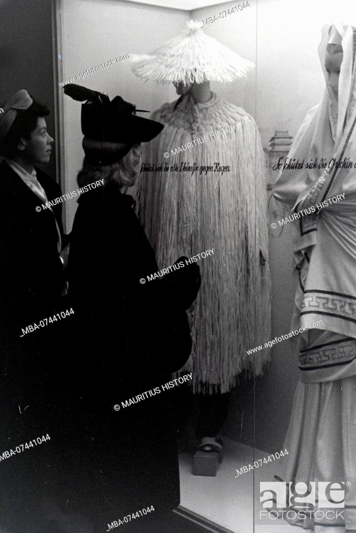 Stock Photo: Visitors to a fair in front of a display case with Chinese and Greek costumes, on the occasion of the Wiener Modewoche in the house of fashion Palais Lobkowitz.