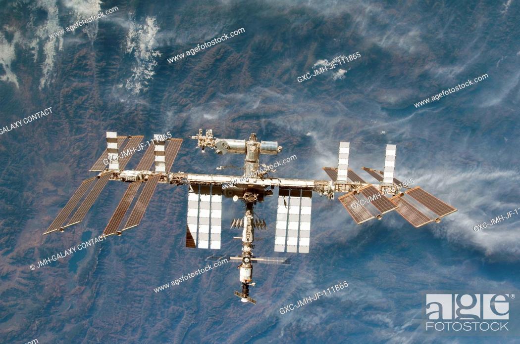 Stock Photo: Backdropped by rugged Earth terrain, the International Space Station is featured in this image photographed by an STS-130 crew member on space shuttle Endeavour.