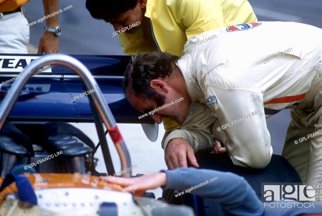 Stock Photo: Denny Hulme looking at the engine of his carat the Questor GP in Ontario 1971.