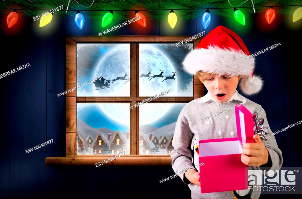 Stock Photo: Composite image of festive boy holding a gift.