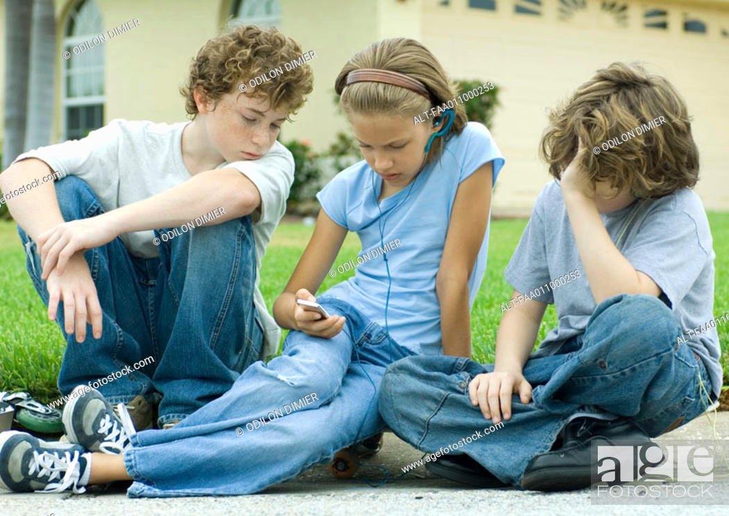 Stock Photo: Children sitting in street, one with mp3 player.