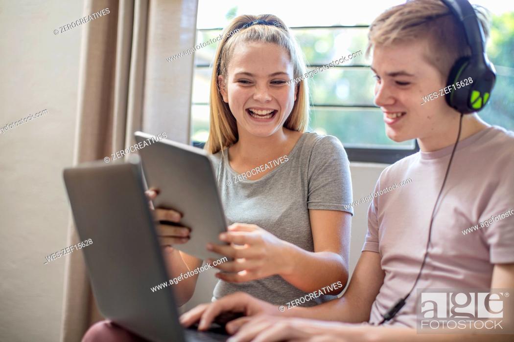 Imagen: Happy boy and teenage girl with tablet, laptop and headphones.