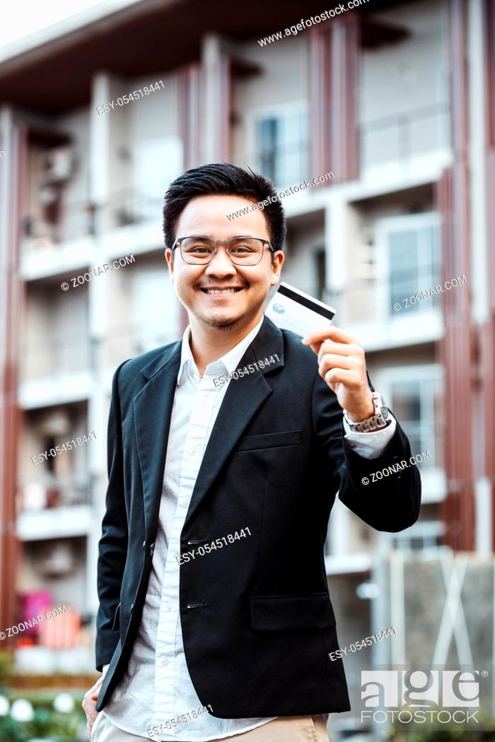 Stock Photo: Young Handsome man enjoy shopping online on mobile phone with credit card.