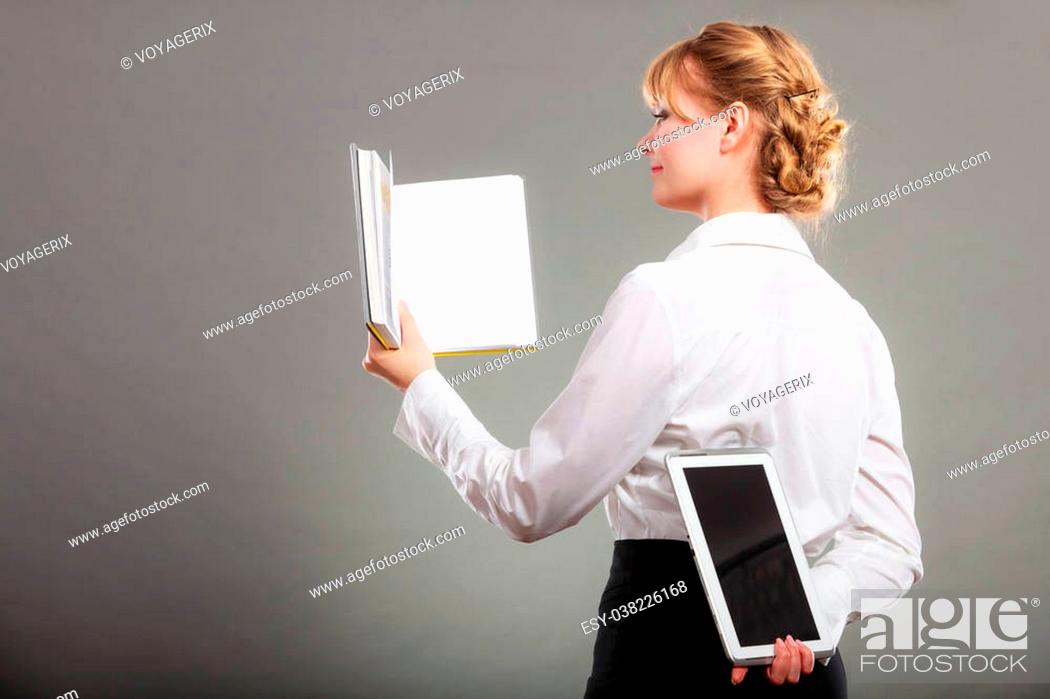 Stock Photo: Woman learning with book holding ebook reader behind back. Choice between modern educational technology and traditional way method.