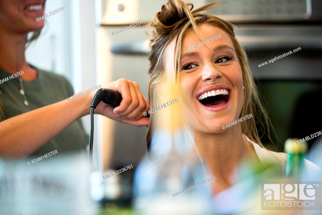 Stock Photo: Caucasian woman smiling with hair stylist.