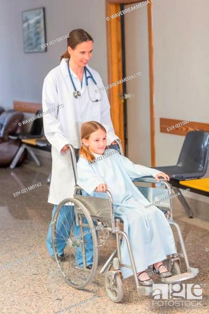 Stock Photo: Doctor wheeling a patient in a wheelchair.
