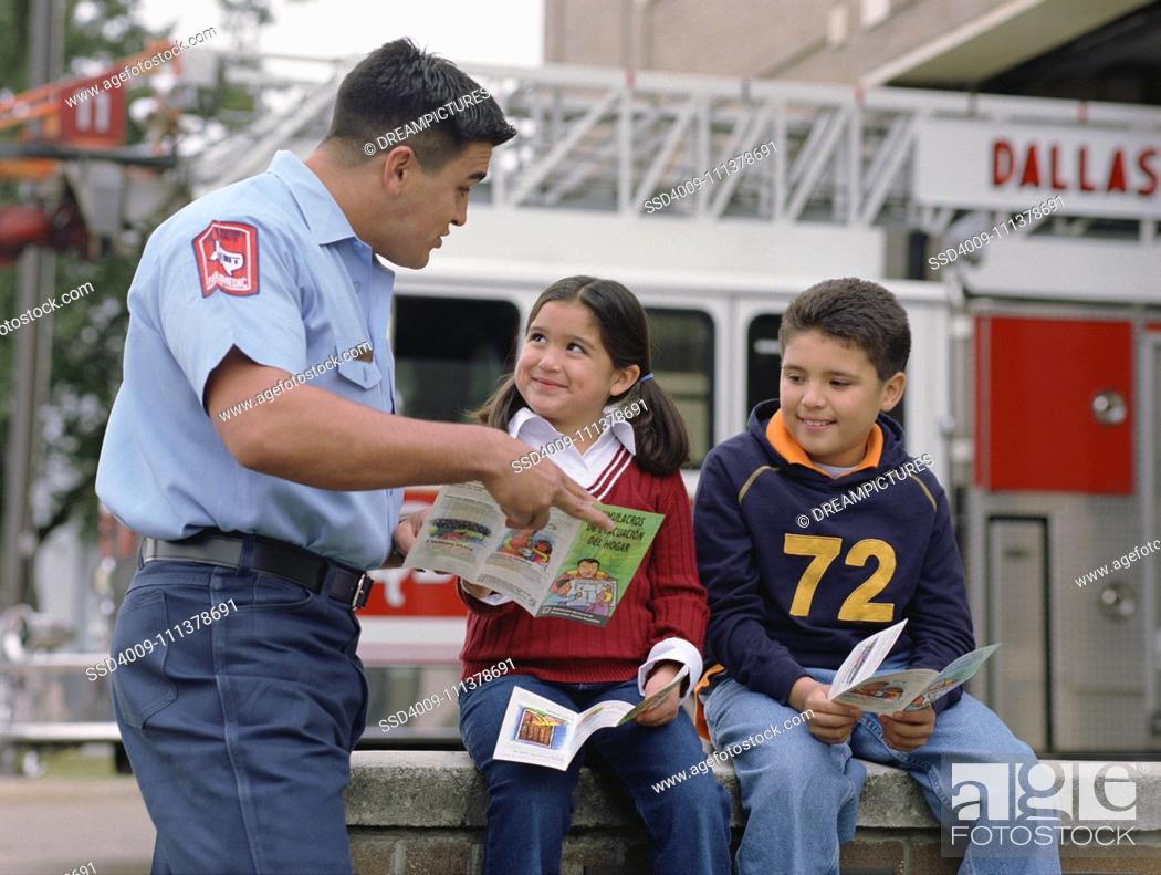 Stock Photo: Fireman talking to young children about fire safety.