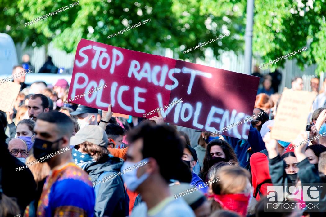 Stock Photo: 30 May 2020, Berlin: Participants in a rally against the violent death of African-American George Floyd by a white policeman hold a poster in front of the U.