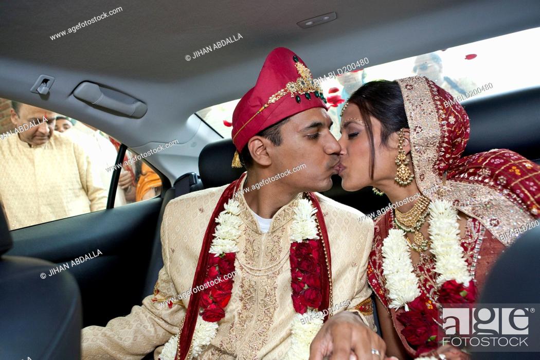 Stock Photo: Indian bride and groom in traditional clothing kissing in car.