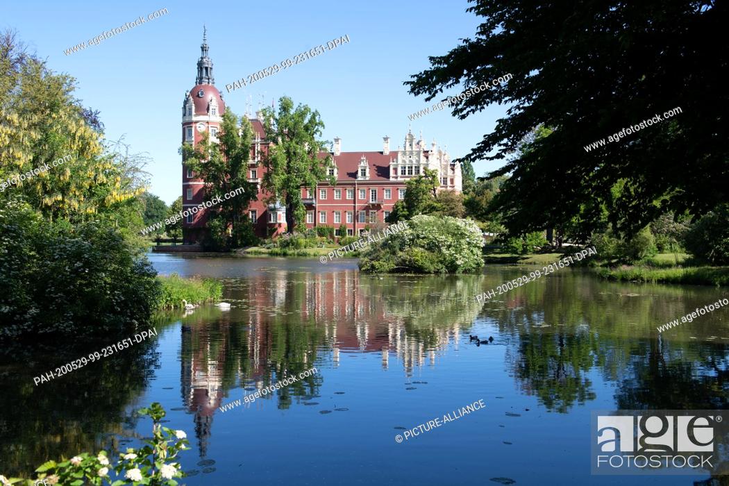 Stock Photo: 29 May 2020, Saxony, Bad Muskau: The castle in the Fürst-Pückler-Park, built in 1520, is reflected in the water. Photo: Sebastian Kahnert/dpa-Zentralbild/dpa.