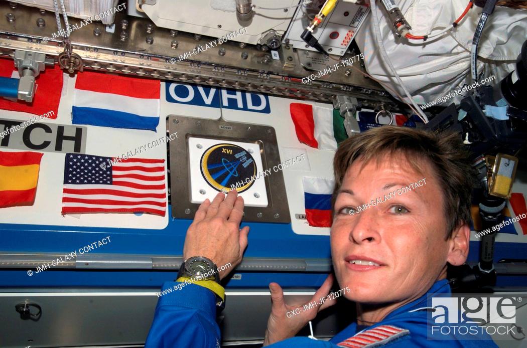 Stock Photo: NASA astronaut Peggy A. Whitson, Expedition 16 commander, places the Expedition 16 patch above a hatch in the Destiny laboratory.