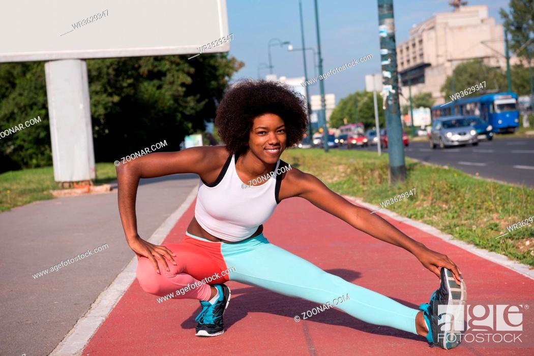 Stock Photo: portrait of a young beautiful African American girl doing stretching beautiful summer morning on the streets of the city.