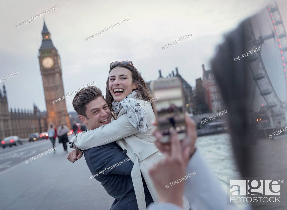 Imagen: Playful couple tourists being photographed on bridge near Big Ben, London, UK.