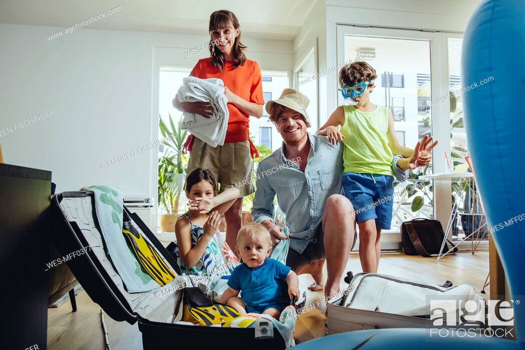 Stock Photo: Happy family of five packing for holiday trip.