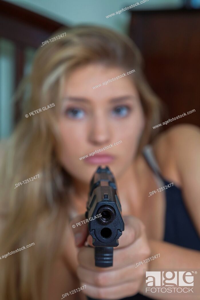 Imagen: Teenage girl with blond hair pointing a gun at the camera; Connecticut, United States of America.