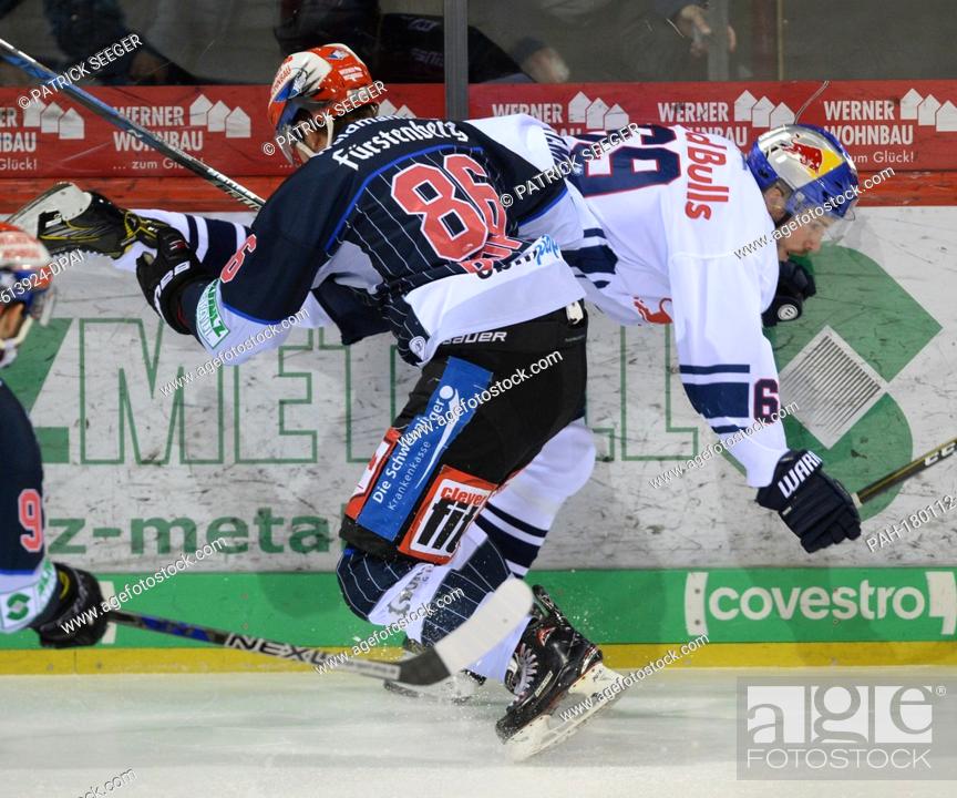 Stock Photo: Schwenningen's Dominik Bohac (L) and Munich's Florian Kettemer (R) vie for the puck during the German Ice Hockey League (DEL) match between Schwenninger Wild.