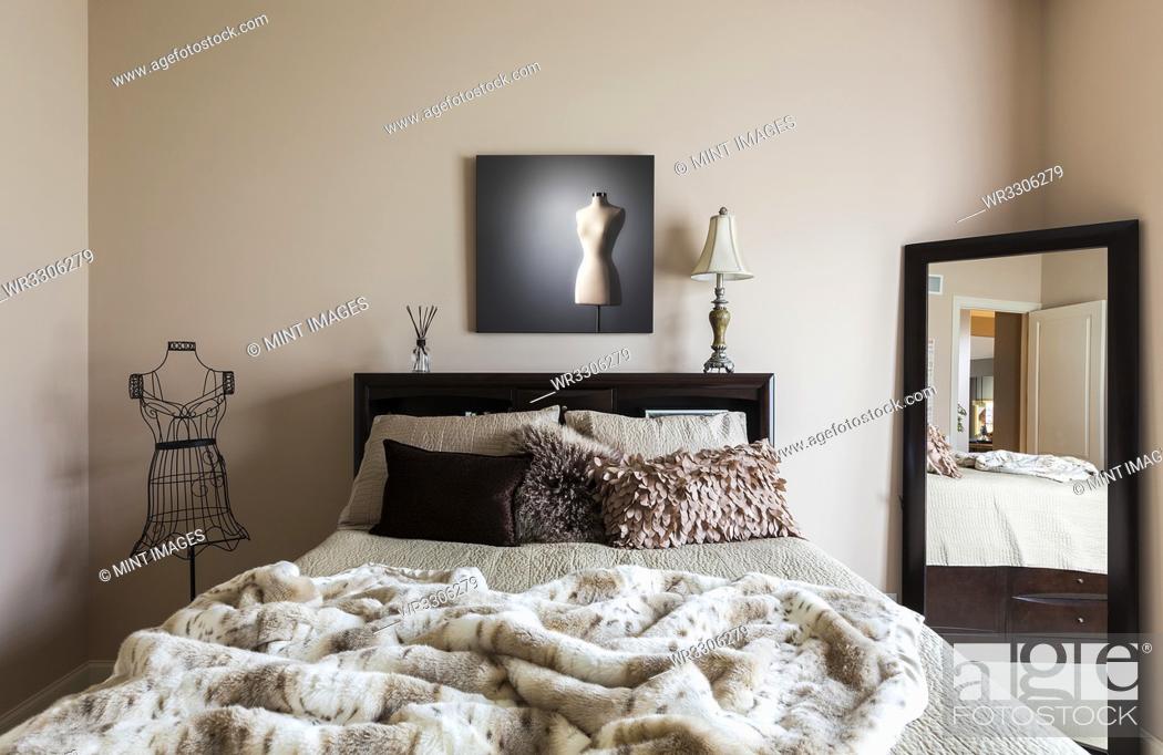 Stock Photo: Mirror, bed and dress form in modern bedroom.