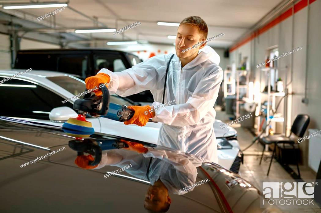 Stock Photo: Professional car service male worker with orbital polisher polishing freshly painted surface.