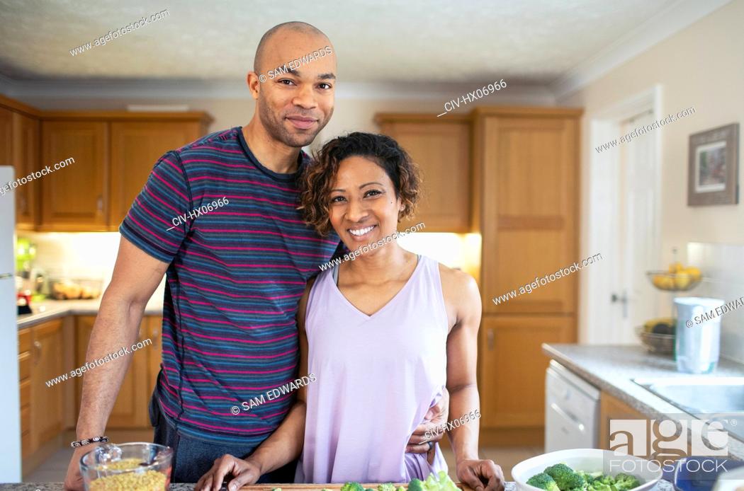 Stock Photo: Portrait smiling couple cooking in kitchen.