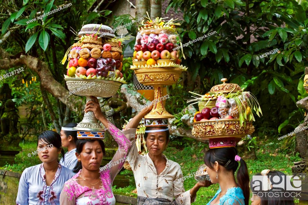 Stock Photo: women carrying offerings of fruits, flowers and pastries to the Pura Tirta Empul temple complex during the Galungan festival, Indonesia, Bali, Tampaksiring.