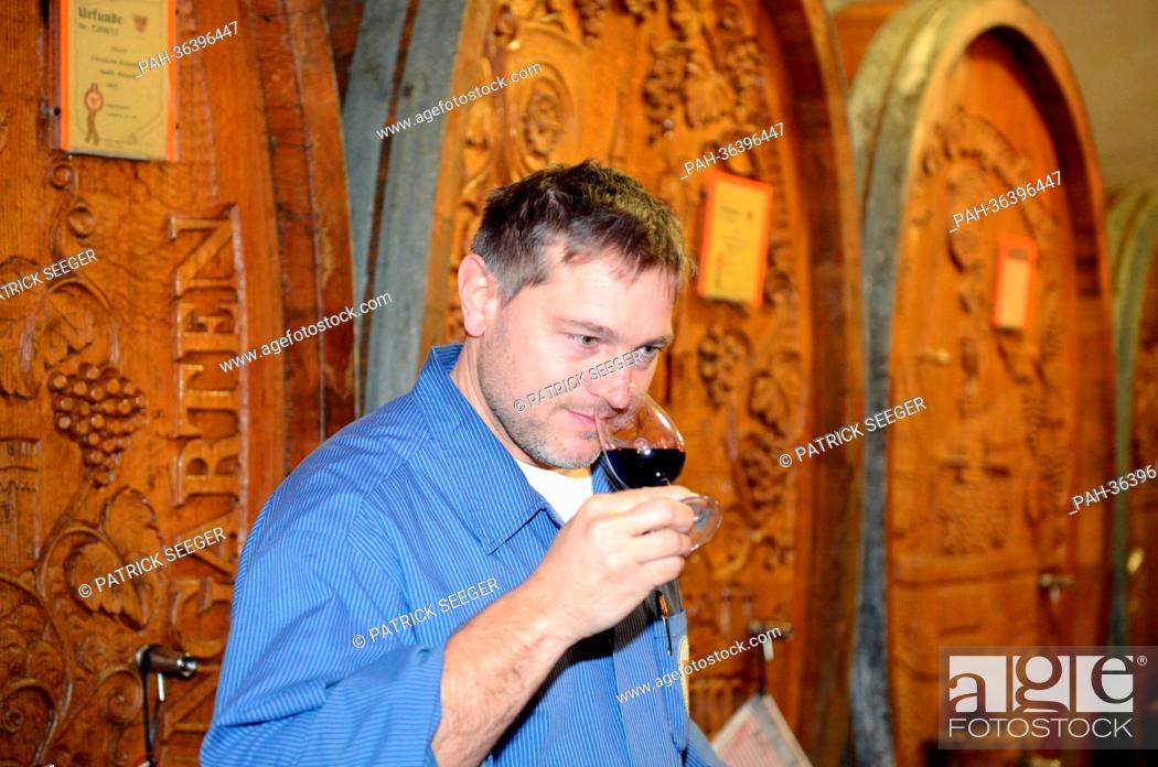 Stock Photo: Cellarer Joerg Wiedemann smells a glass of red wine in the wine cellar of the winery Badische Winzerei in Breisaach, Germany, 21 January 2013.