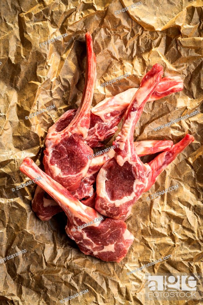 Stock Photo: Slices raw lamb chops on baking paper. Top view.