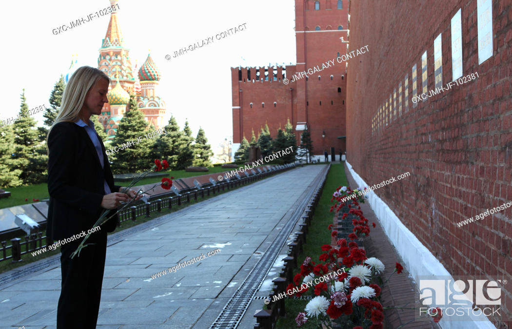 Stock Photo: Expedition 3637 Flight Engineer Karen Nyberg of NASA takes a moment to pay tribute to Russian space icons interred in the Kremlin Wall during a tour of Red.
