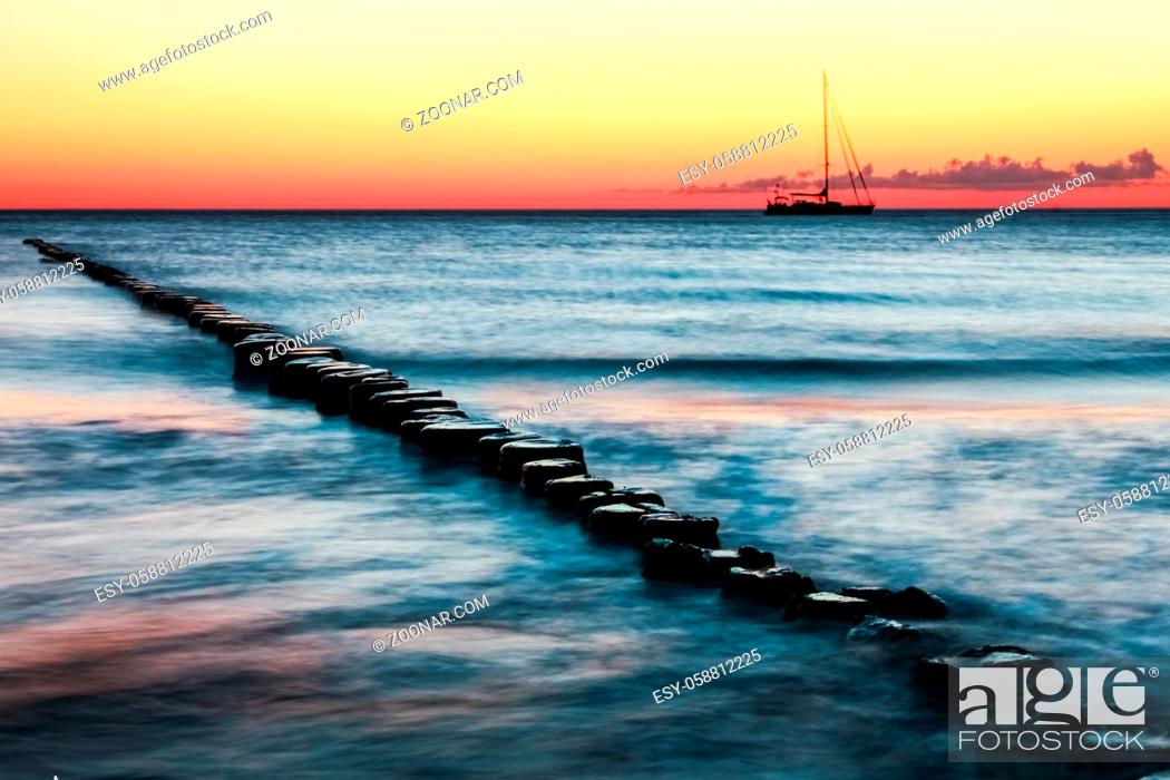Stock Photo: Wooden spur dykes in coastal sunset. Old groynes and wavy sea water, Baltic Sea, Island of Hiddensee, Germany.