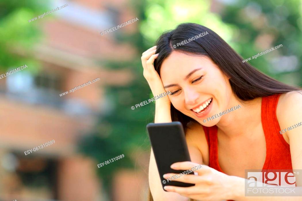 Stock Photo: Happy asian woman checking phone message in the street.