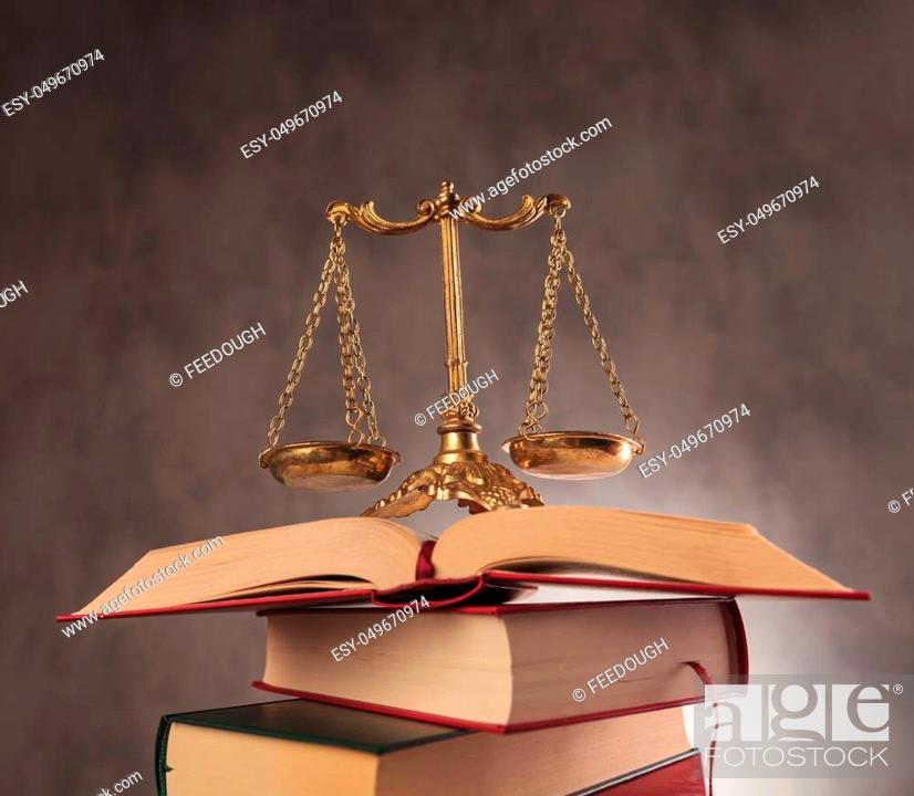Stock Photo: learning to be fair in all decisions. antique scale on top of a pile of books, studying law concept.