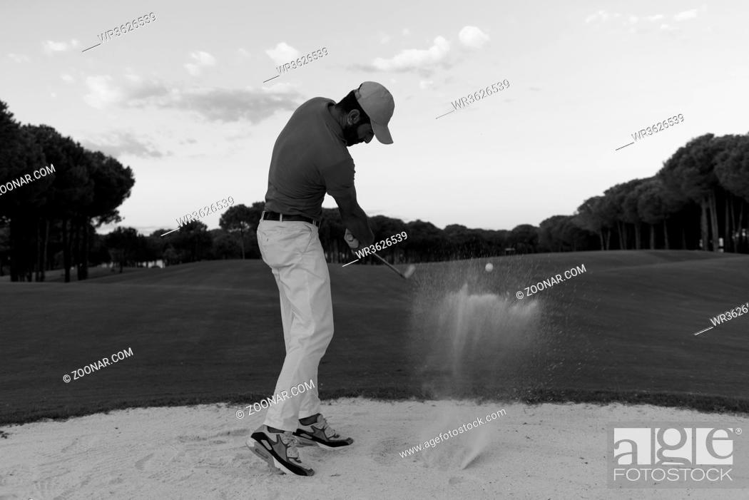 Stock Photo: golf player shot ball from sand bunker at course with beautiful sunset with sun flare.