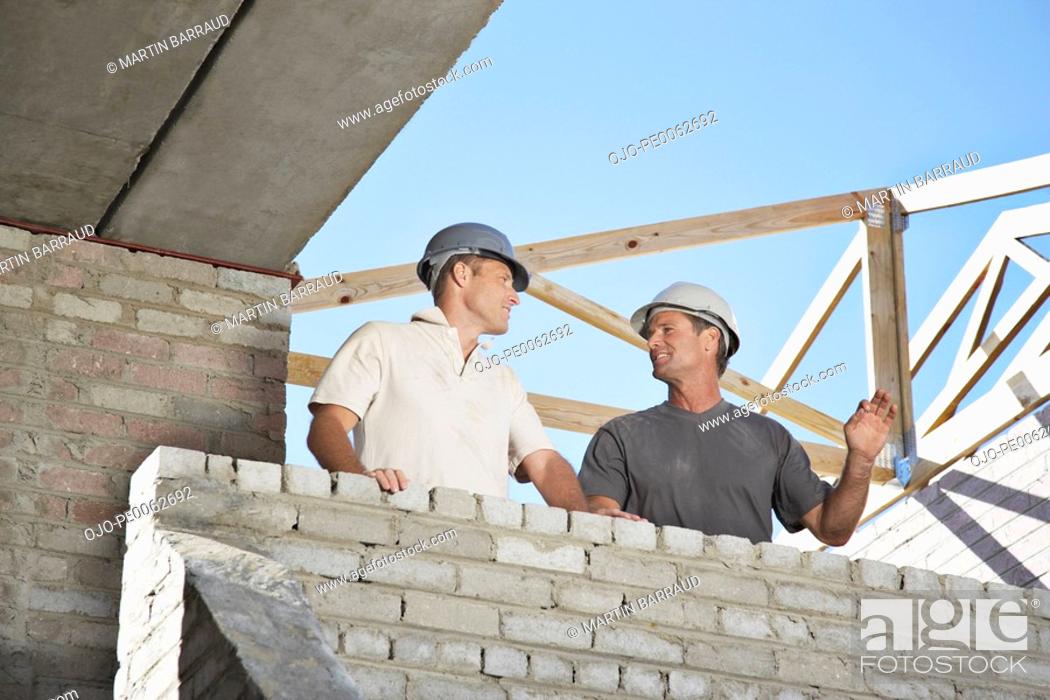 Stock Photo: Construction workers inside unfinished new home.