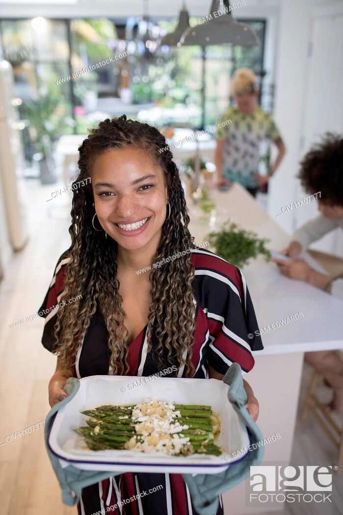 Stock Photo: Portrait happy woman cooking asparagus in kitchen.