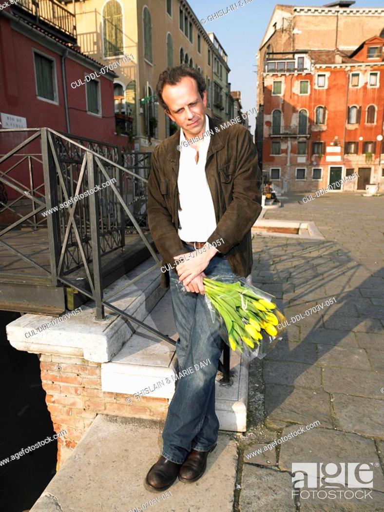 Stock Photo: Man waiting with bunch of tulips Venice, Italy.