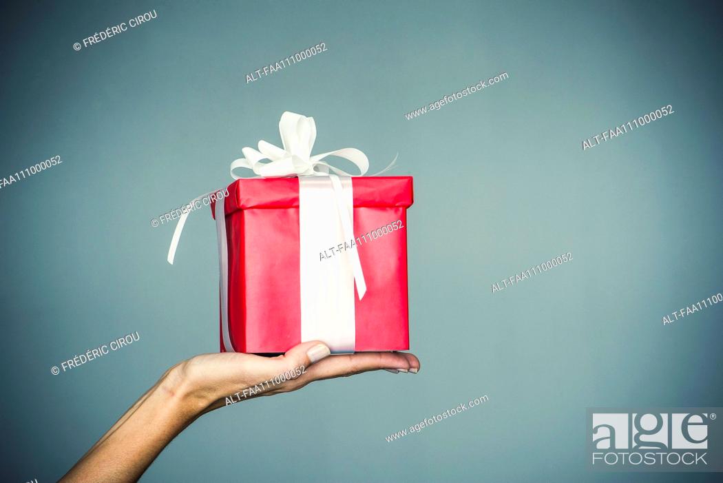 Imagen: Woman's hand holding wrapped gift.
