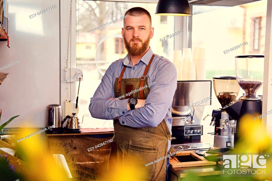 Stock Photo: Portrait of bearded redheads seller in a small coffee house.