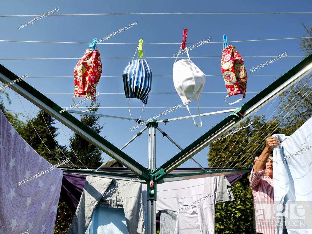 Stock Photo: 08 April 2020, North Rhine-Westphalia, Mülheim: The 79-year-old pensioner Inge Vincents has hung up her self-sewn masks to dry after 60 degrees washing.