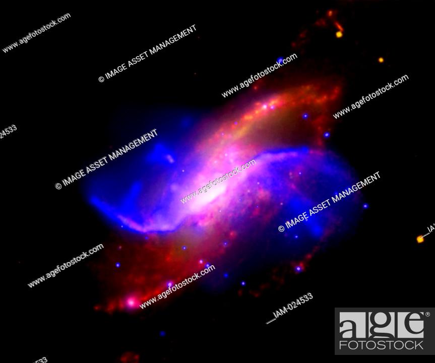 Stock Photo: In this composite image of spiral galaxy M106 (NGC 4258), optical data from the Digitized Sky Survey is shown as yellow, radio data from the Very Large Array.