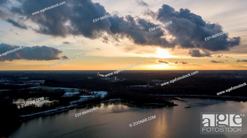 Stock Photo: Aerial view of a beautiful and dramatic sunset over a forest lake reflected in the water, landscape drone shot. Blakheide, Beerse, Belgium.
