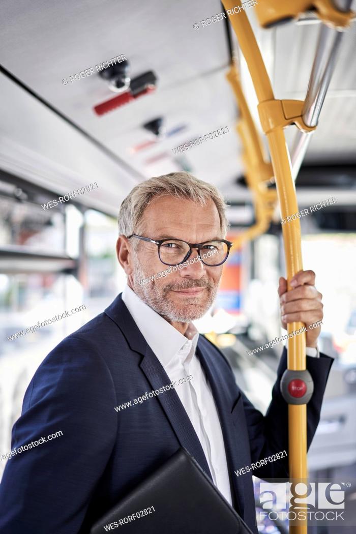 Stock Photo: Senior businessman standing in bus.