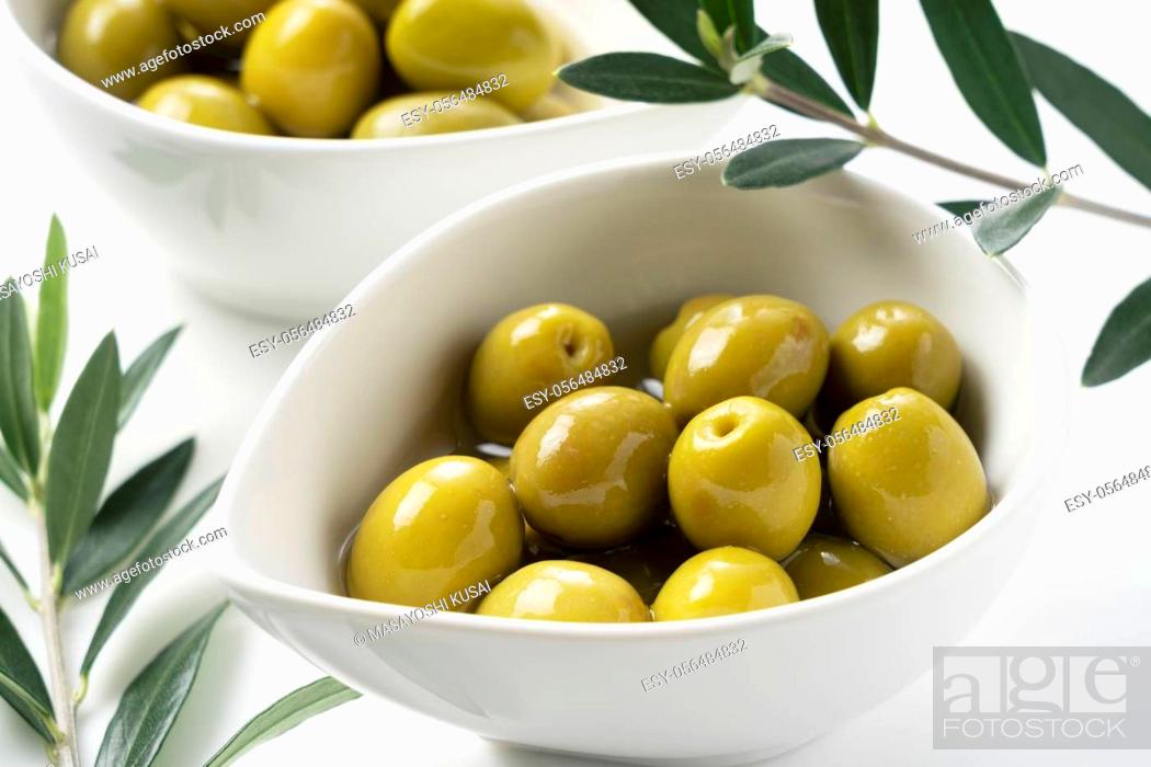 Stock Photo: Salted olives and olive branches placed on a white background.