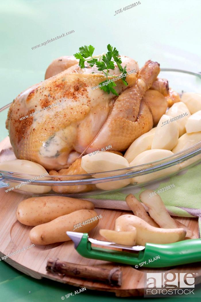 Stock Photo: Placing the peeled potatoes around the chicken in a baking dish.